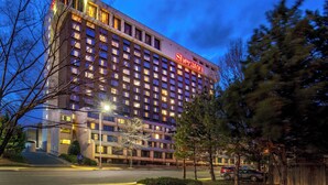 A Sheraton hotel with multiple floors, a prominent sign, and a well-lit facade. - Sheraton Pentagon City Hotel (Arlington)
