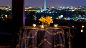 A table with a dark cloth and candles, overlooking a cityscape at night. - Sheraton Pentagon City Hotel (Arlington)