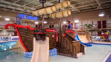 An indoor water park with a pirate ship-themed play area, including slides and a pool.