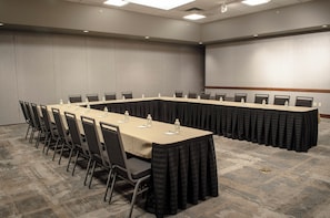 A conference room with a long table, chairs, and water bottles.