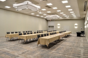 A conference room with multiple tables and chairs, equipped with nameplates and water glasses.