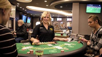 A casino environment with a blackjack table, a dealer, and patrons.
