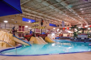 An indoor swimming pool with slides and a bar area. - Holiday Inn Fargo by IHG (Fargo)