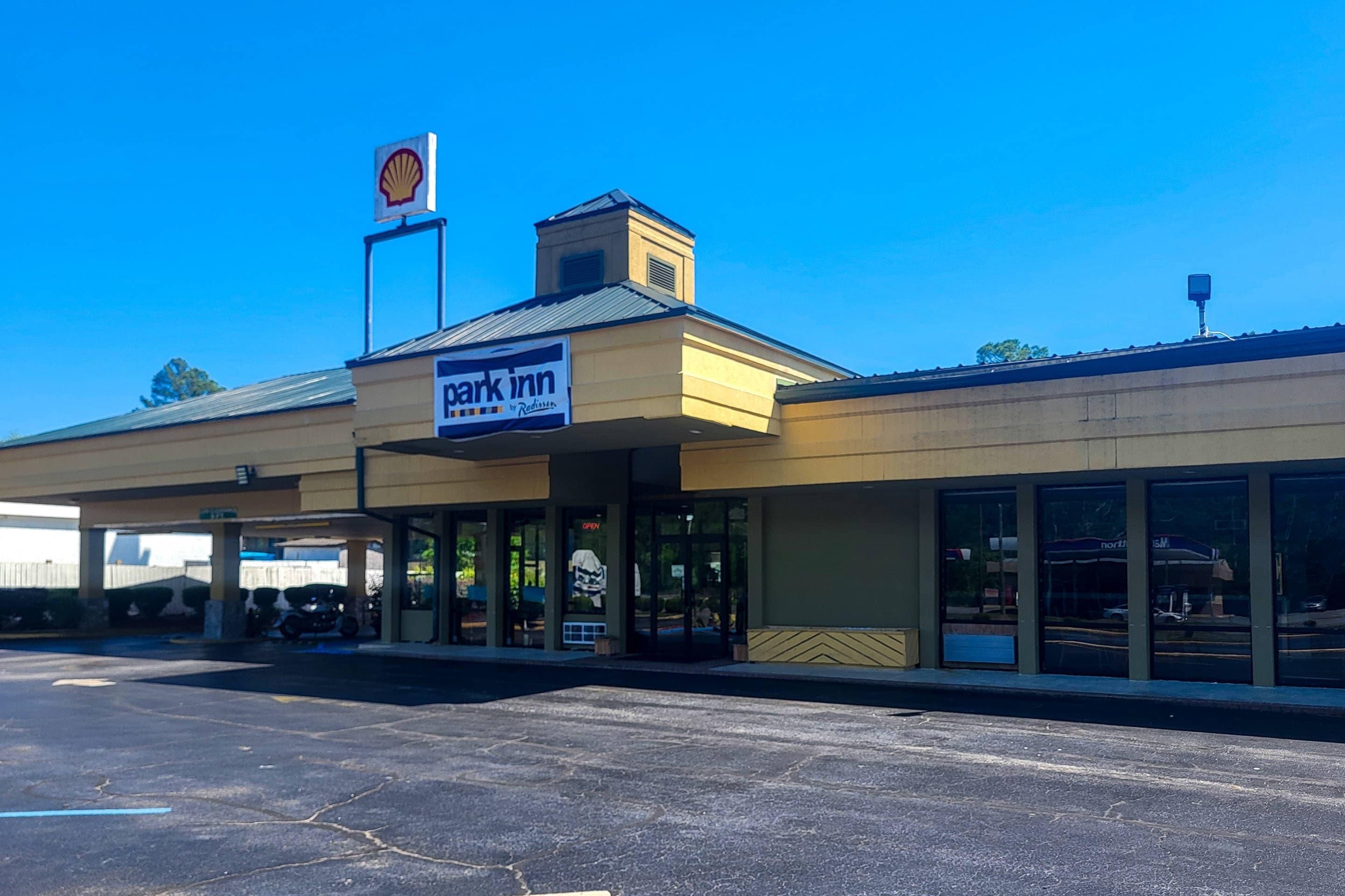A parking lot with a Shell gas station and a Park Inn by Radisson sign.