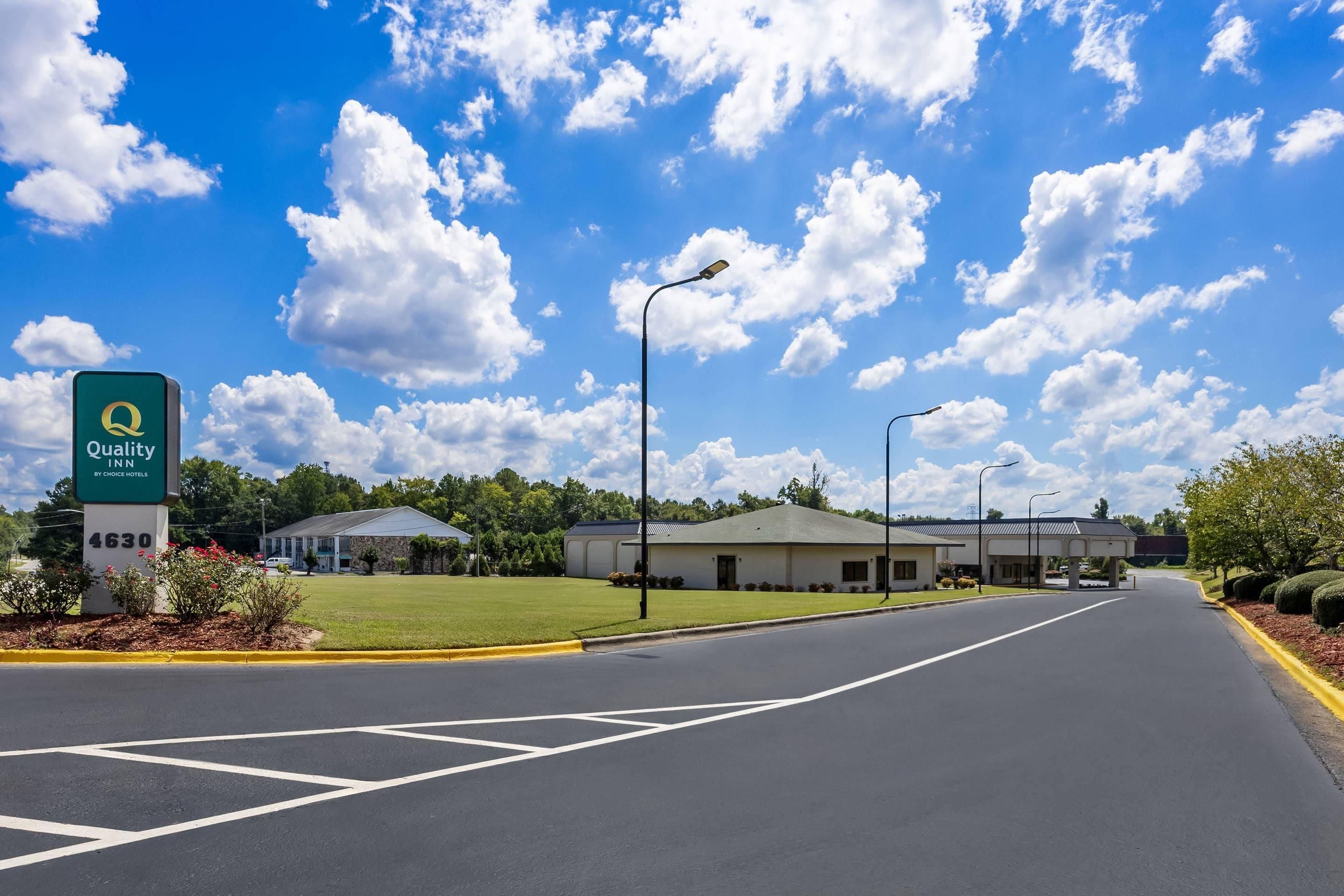 A Quality Inn hotel with a clear sky and a well-maintained parking lot.