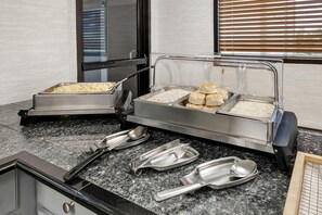 A buffet setup with various food items and serving utensils. - Quality Inn Macon West (Macon)