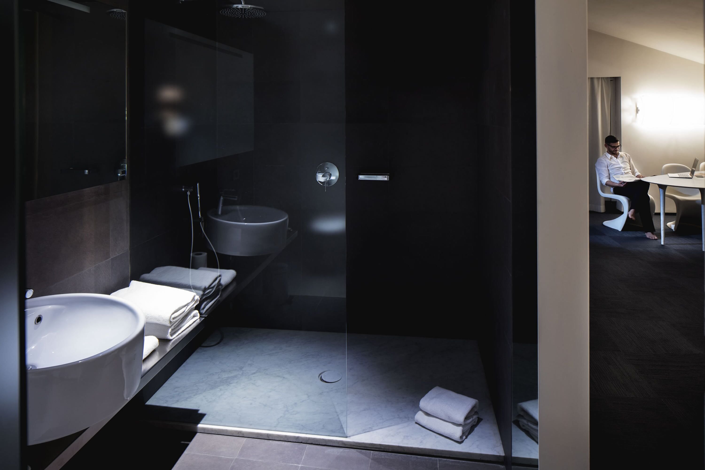 A modern bathroom with a glass-enclosed shower, a sink, and a mirror.
