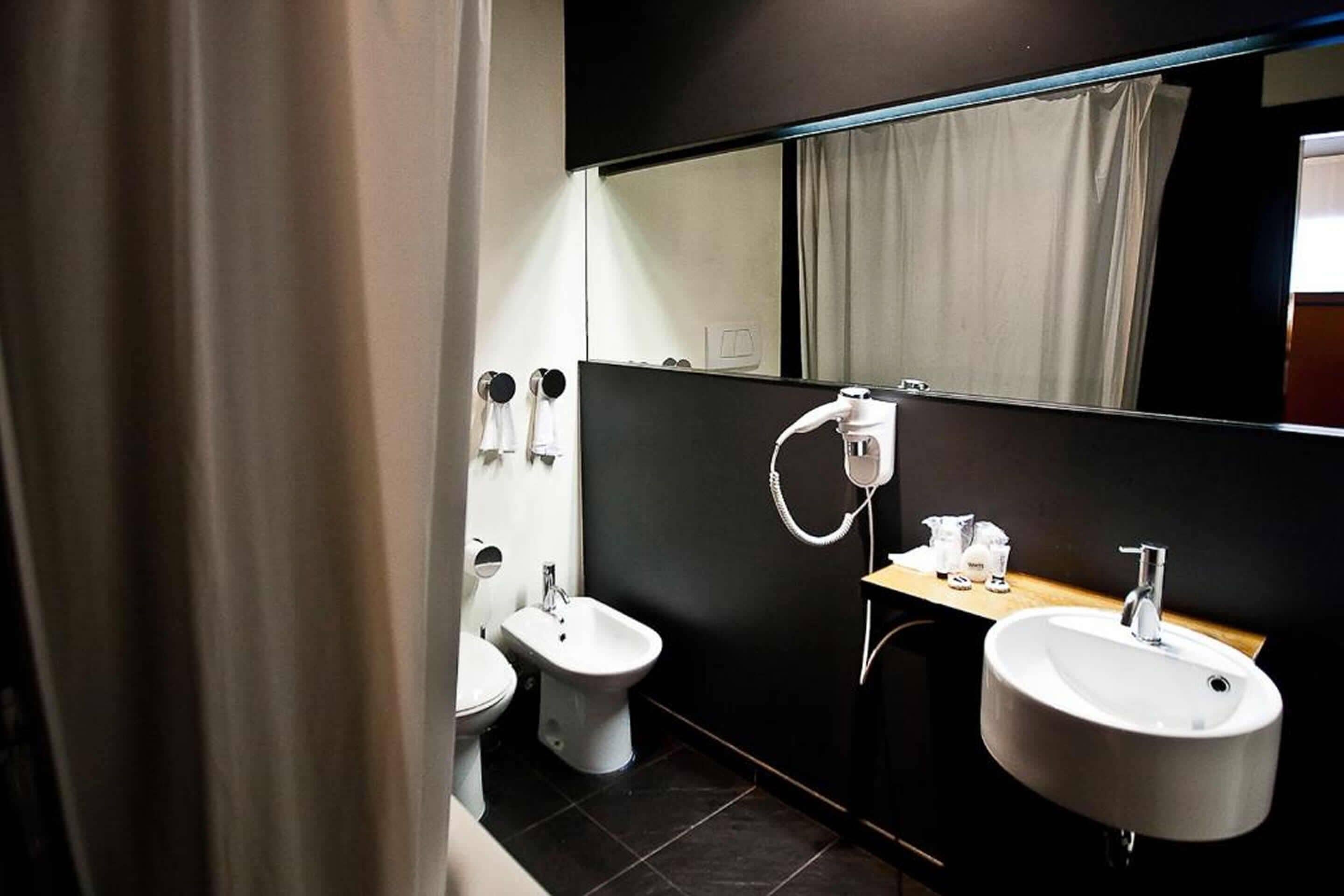 A modern bathroom with a bidet, a sink, and a mirror.