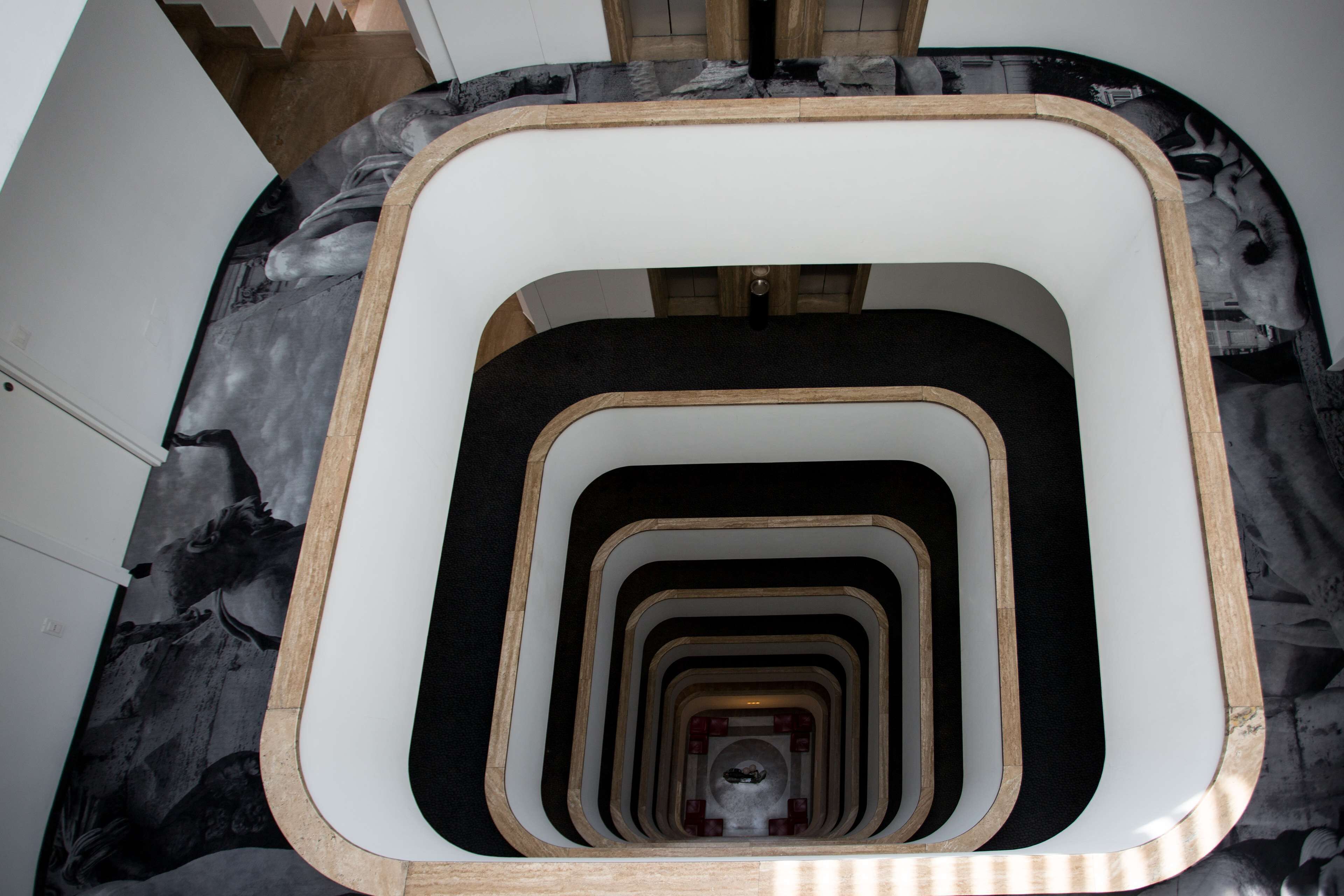 A spiral staircase with a black and white marble floor.