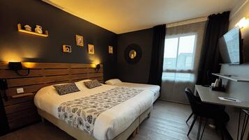 A modern hotel room with a wooden headboard, a large bed with patterned bedding, a desk with a chair, and a view of the city through the window.