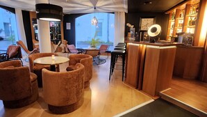 A bar area with wooden furniture, a bar counter, and a large window providing a view outside.