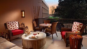 A cozy outdoor seating area with wicker furniture, a round wooden table, and a view of the cityscape. - Sonesta Nashville Airport (Nashville)