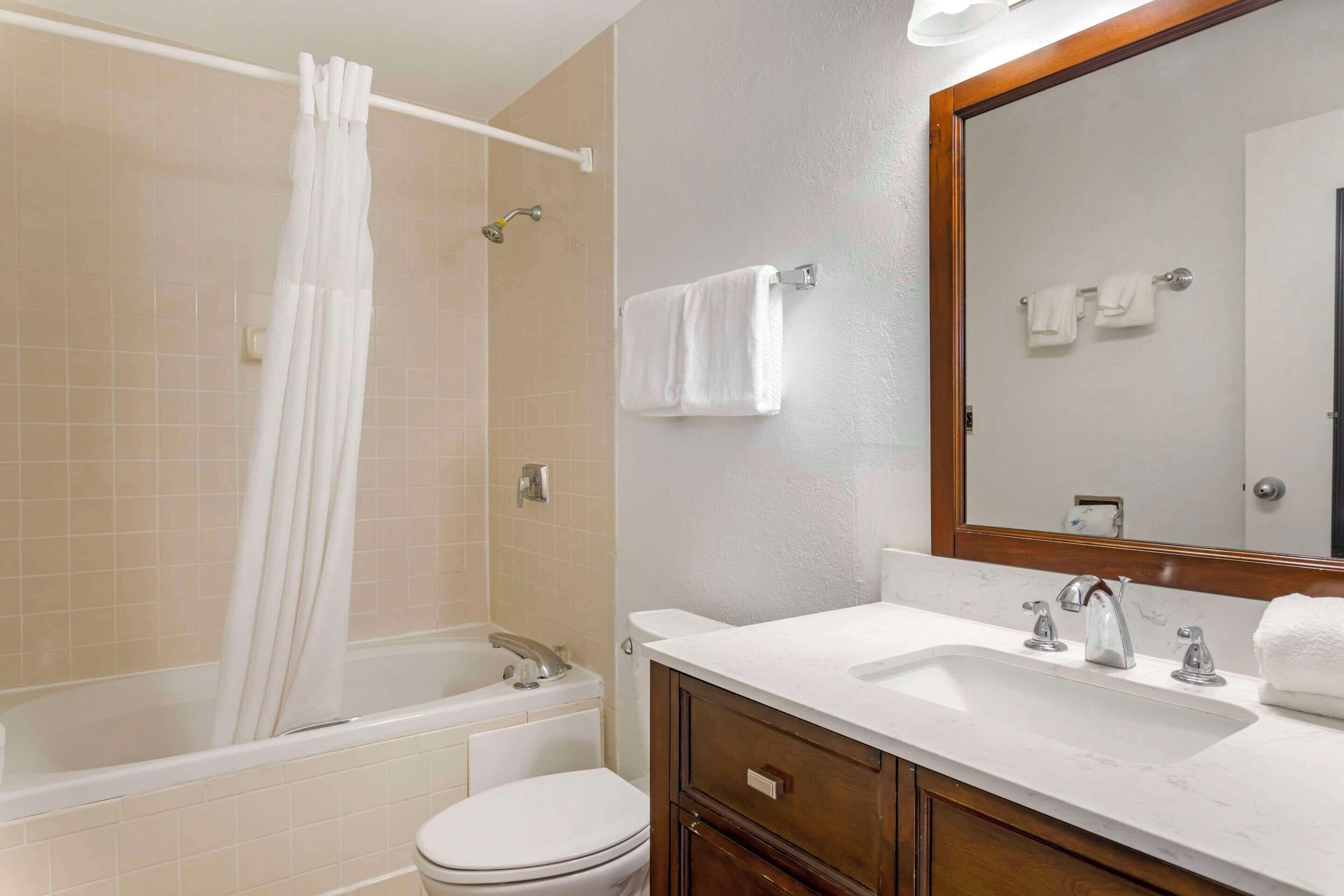 A bathroom with a bathtub, toilet, and sink.