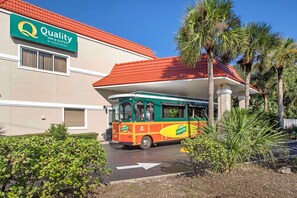 Un autobús estacionado frente a un edificio con un letrero que dice 'Quality Inn & Suites by Choice Hotels'.