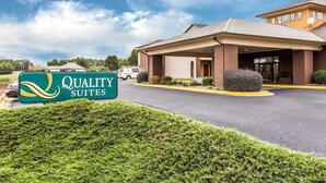 A hotel with a covered entrance, a sign reading 'Quality Suites,' and a parking lot. - Quality Suites Hickory South (Hickory)