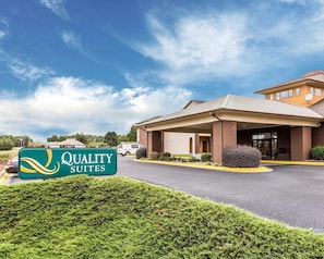 A hotel with a covered entrance, a sign reading 'Quality Suites,' and a parking lot. - Quality Suites Hickory South (Hickory)