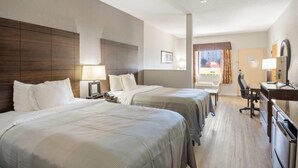 A hotel room with two beds, a desk, a chair, a TV, and a window with curtains. - Quality Suites Hickory South (Hickory)