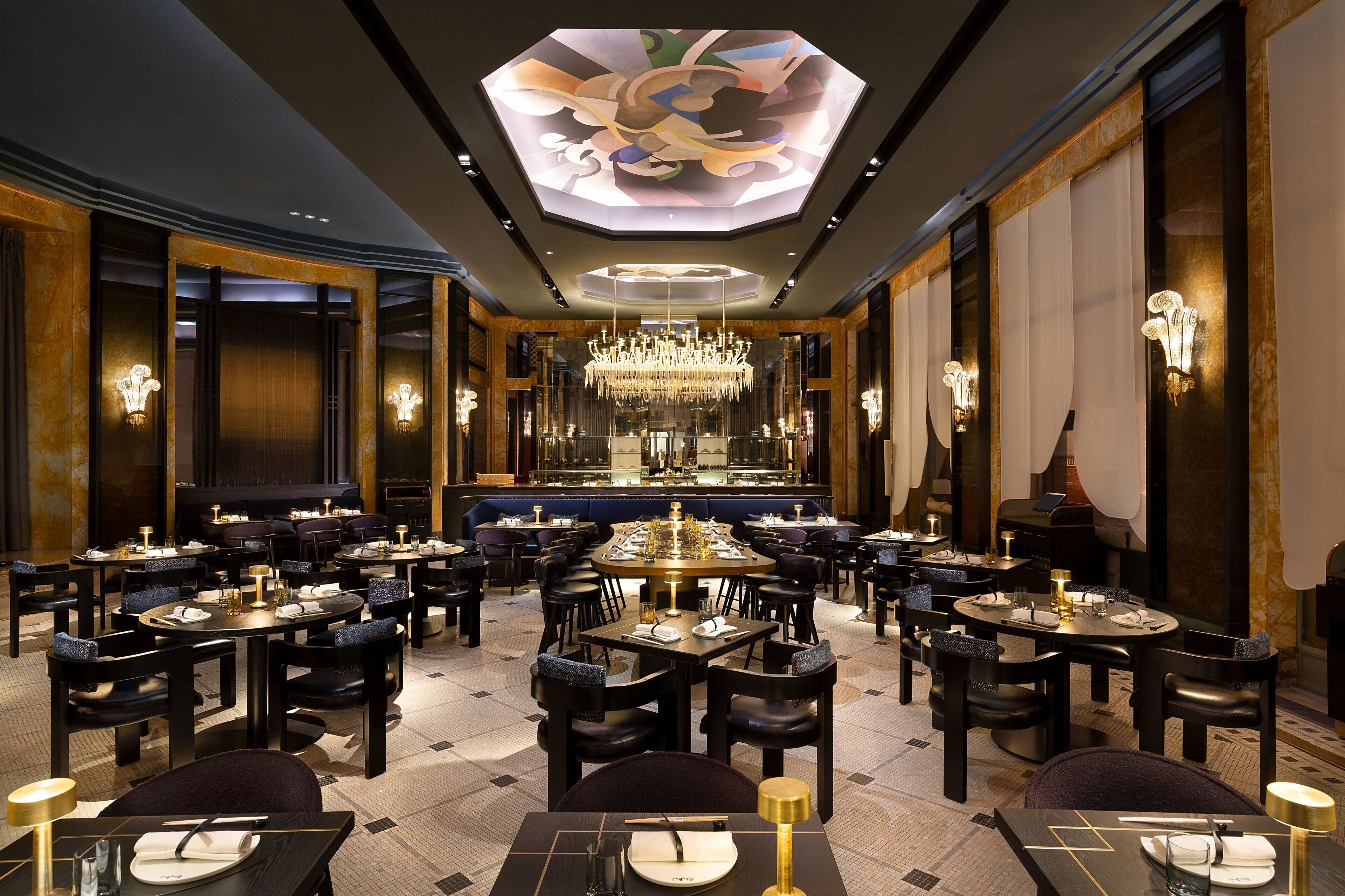 Un restaurant espaiós i amb un disseny elegant, amb nombroses taules i cadirees, i un penjall central.
