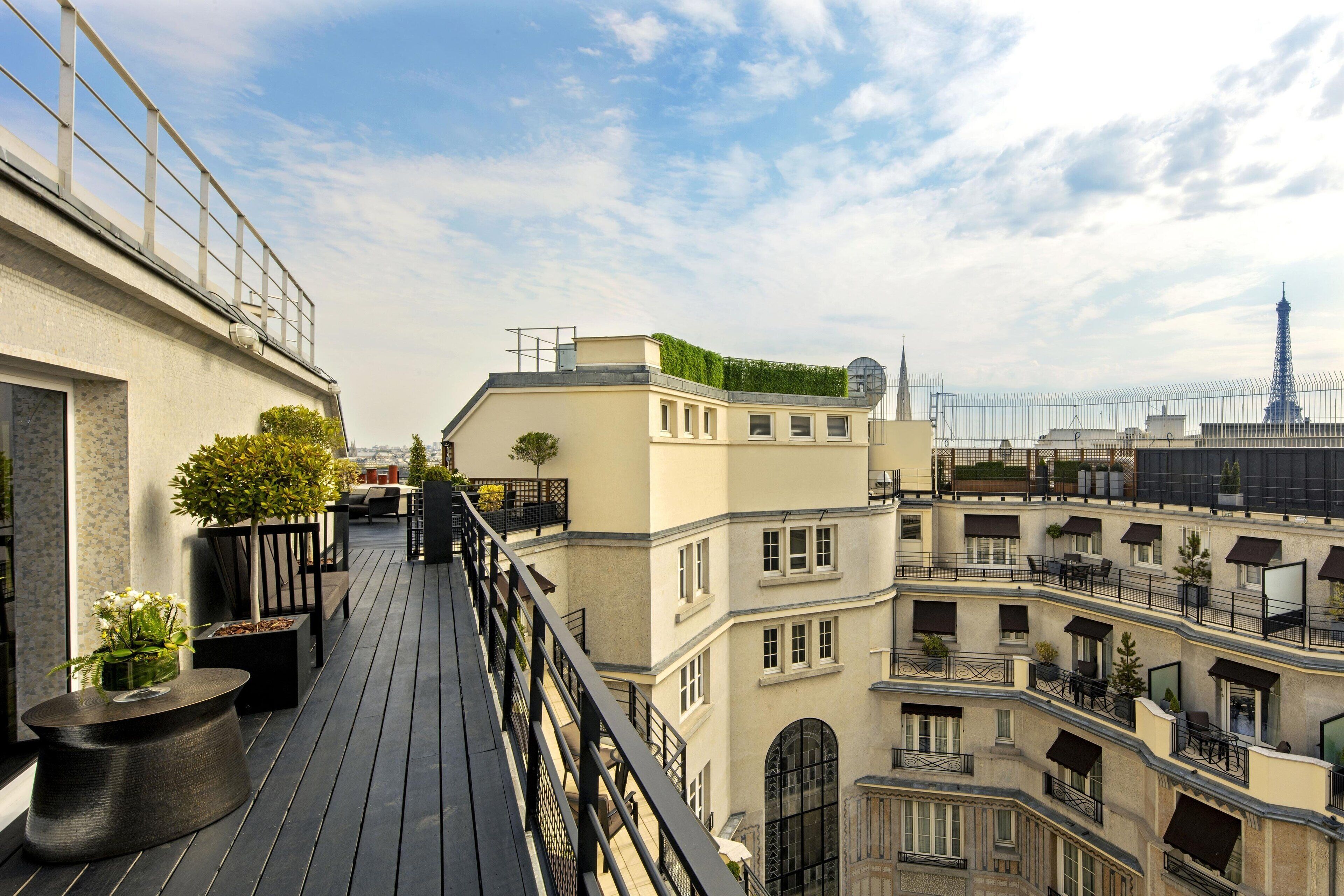 Un immeuble à plusieurs étages doté de balcons, d’un jardin sur le toit et offrant une vue sur la Tour Eiffel.