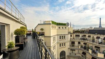 Un immeuble à plusieurs étages doté de balcons, d’un jardin sur le toit et offrant une vue sur la Tour Eiffel.