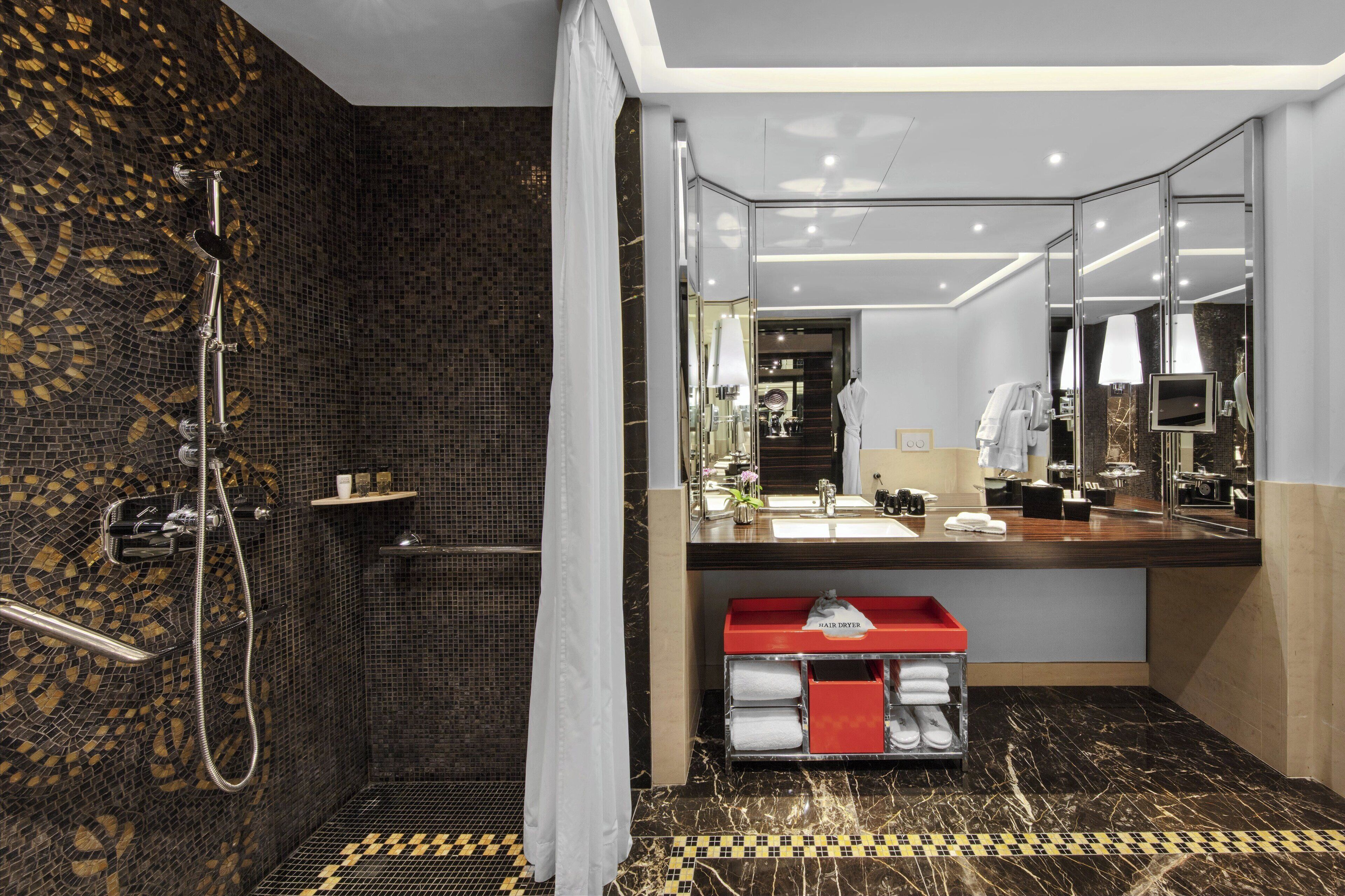A modern bathroom with a shower, a vanity with a mirror, and a hair dryer.