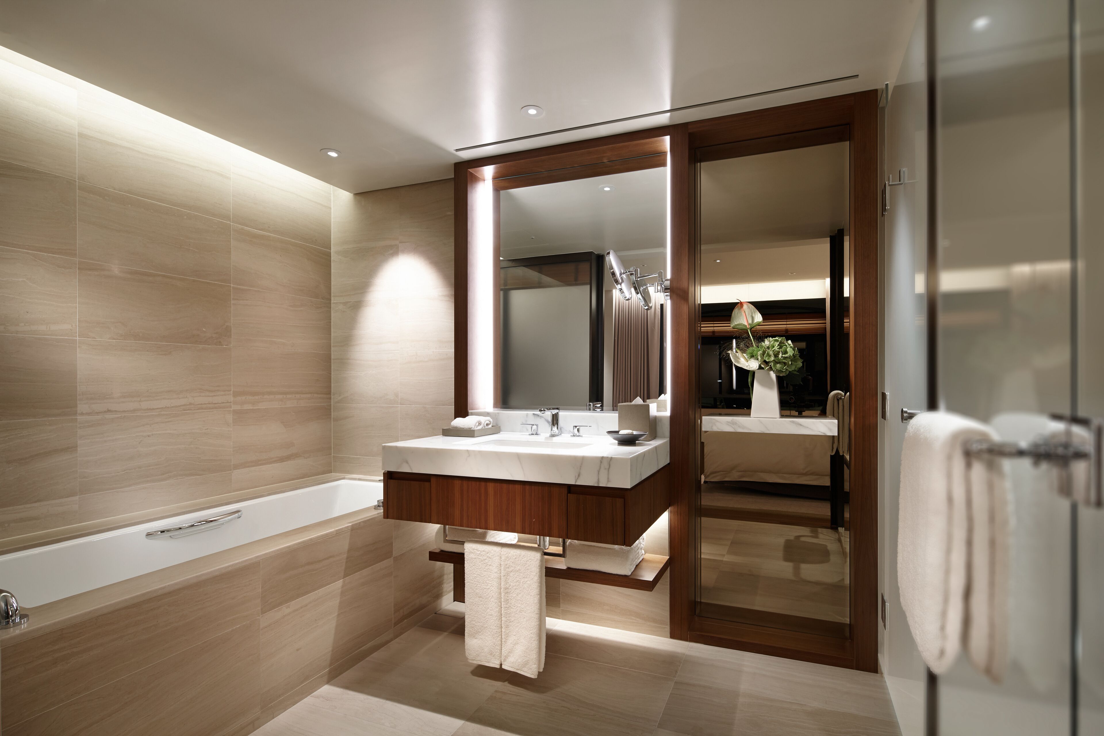 Un baño moderno con una bañera grande, un tocador con espejo y una zona de ducha.