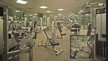 A gym with various exercise machines, mirrors, and a carpeted floor.