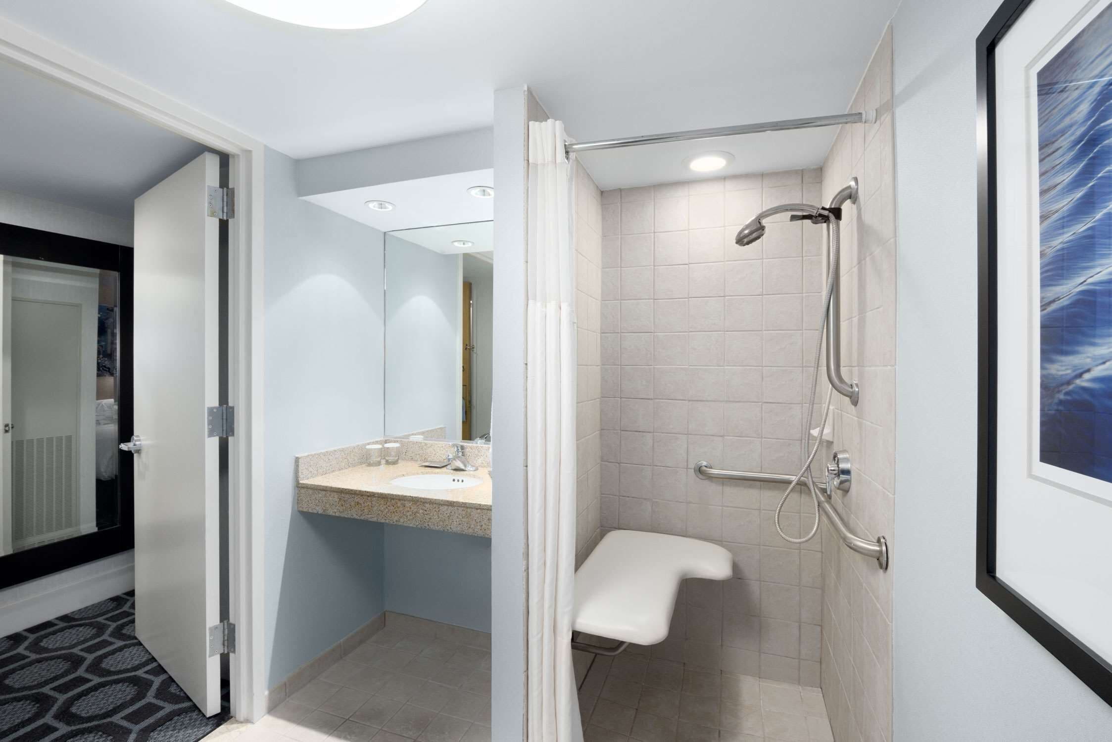 A modern bathroom with a shower, toilet, and sink.