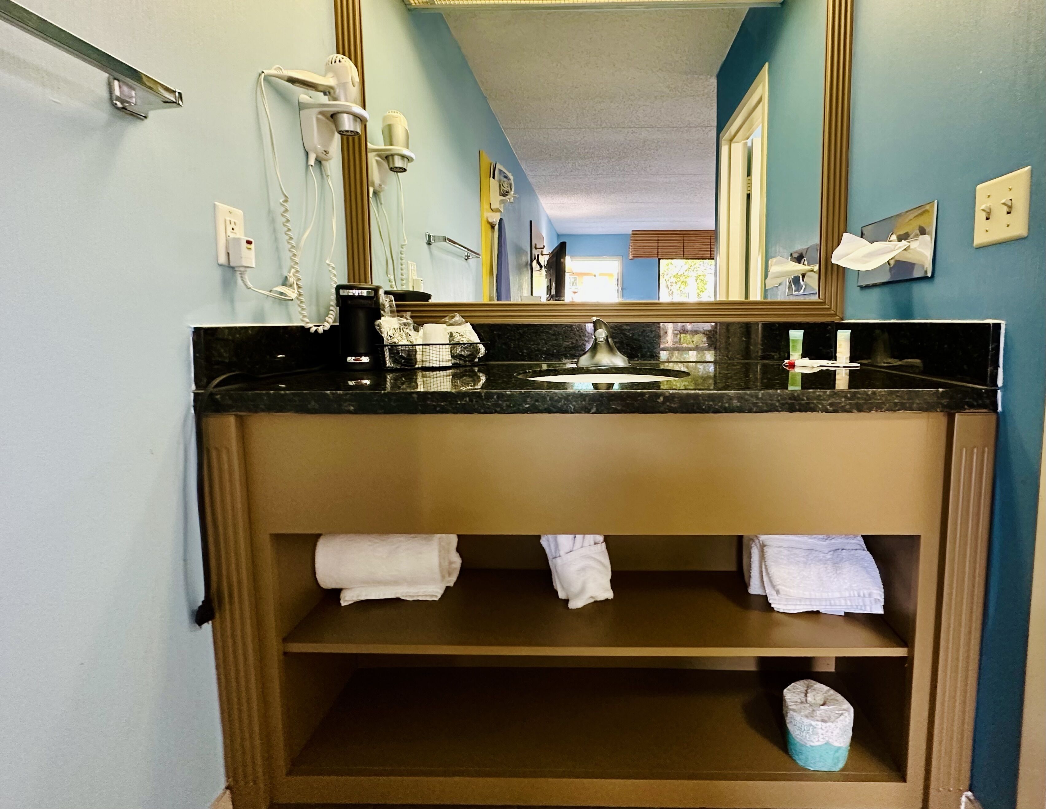 A bathroom with a sink, towel rack, and a mirror.