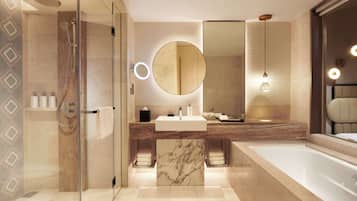 A modern bathroom with a glass-enclosed shower, a marble sink, and a large mirror.
