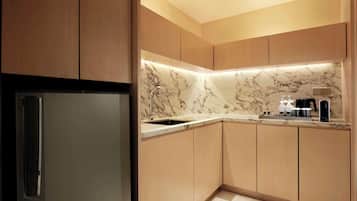 Une cuisine moderne avec des meubles en bois, un pare-feu en marbre et un réfrigérateur en acier inoxydable.