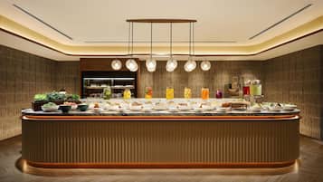 A modern kitchen with a central island, pendant lighting, and a built-in refrigerator.