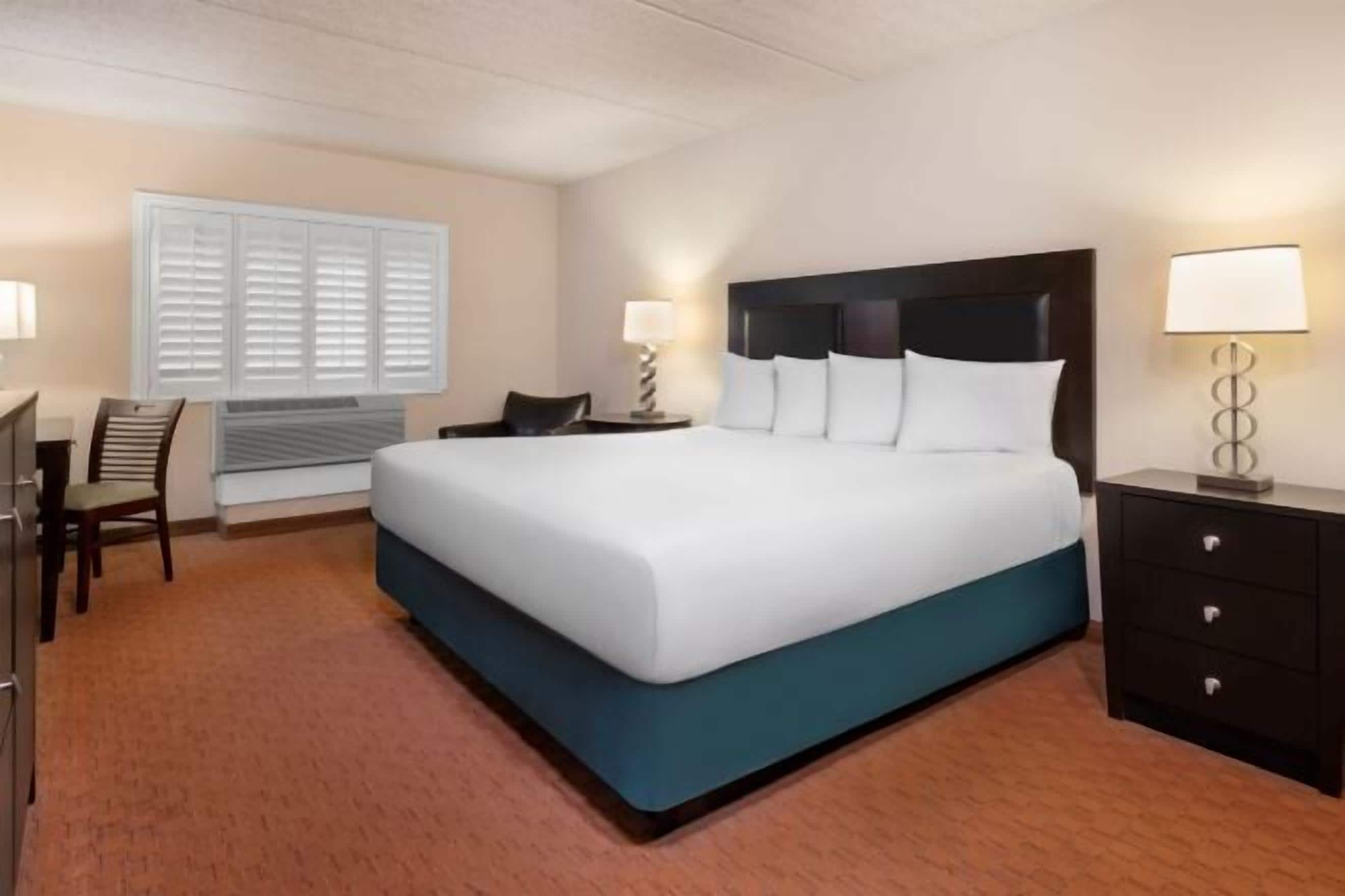 Desk, laptop workspace, iron/ironing board, bed sheets