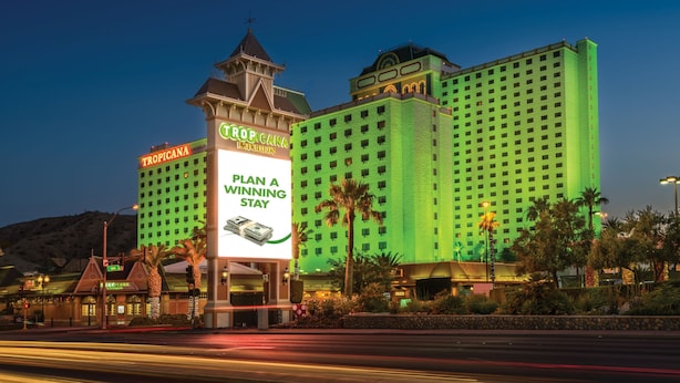 A large hotel with a prominent sign advertising a 'Plan a Winning Stay'. - Tropicana Laughlin Hotel & Casino - A Caesars Rewards Destination (Laughlin)
