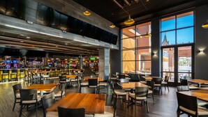 A spacious restaurant with high ceilings, large windows, and a bar area visible in the background. - Tropicana Laughlin Hotel & Casino - A Caesars Rewards Destination (Laughlin)