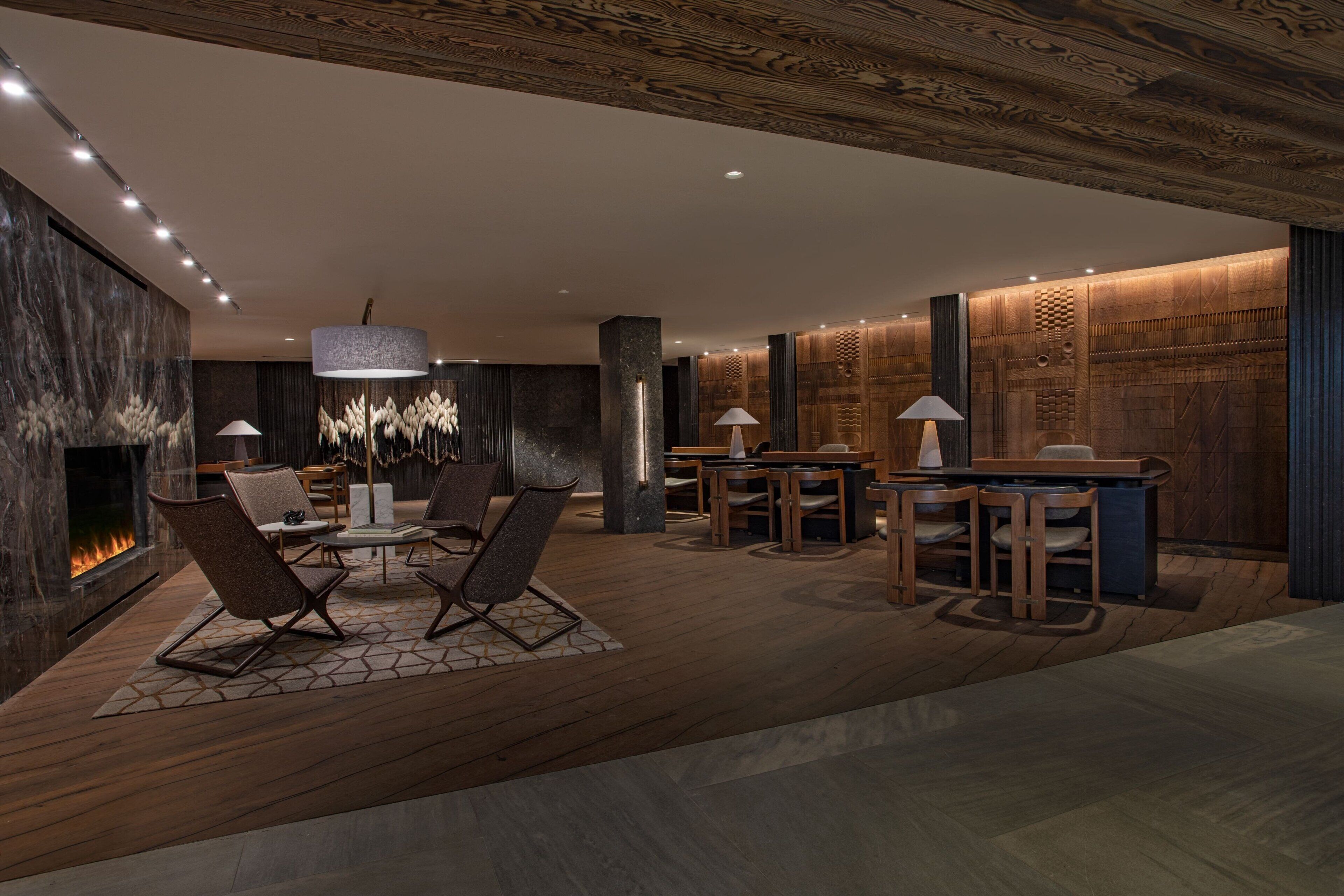 Un intérieur moderne avec une cheminée, un plancher en bois et des meubles contemporains.