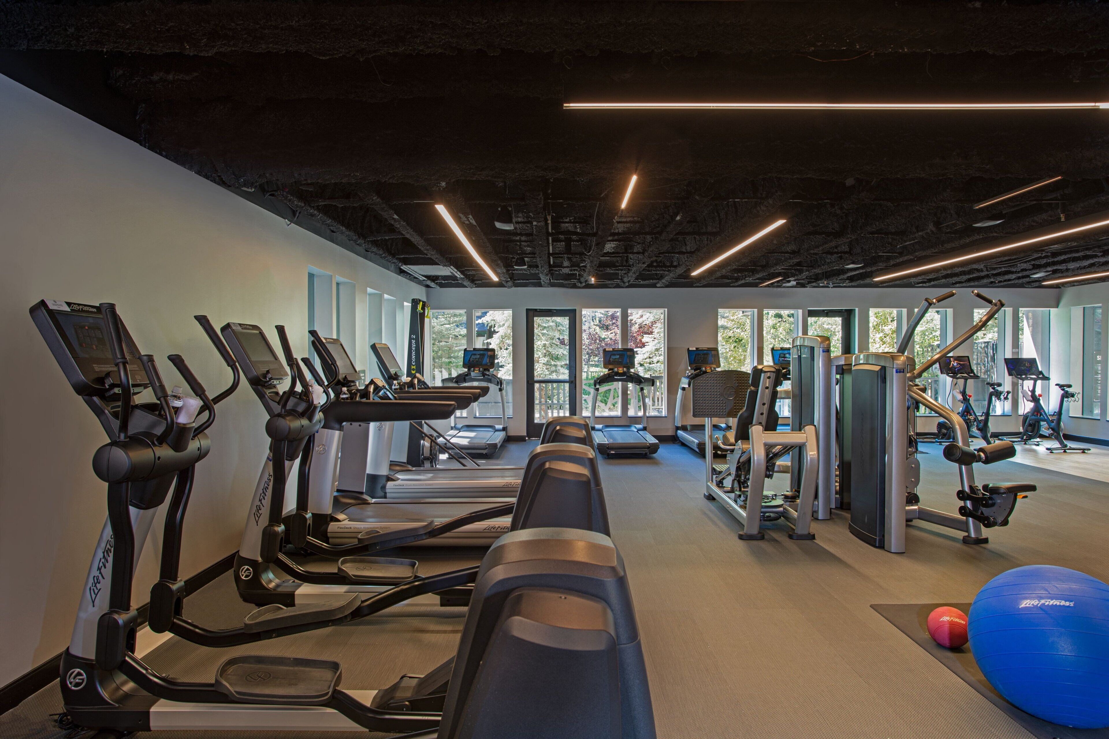A gym with treadmills, elliptical machines, and weight equipment.