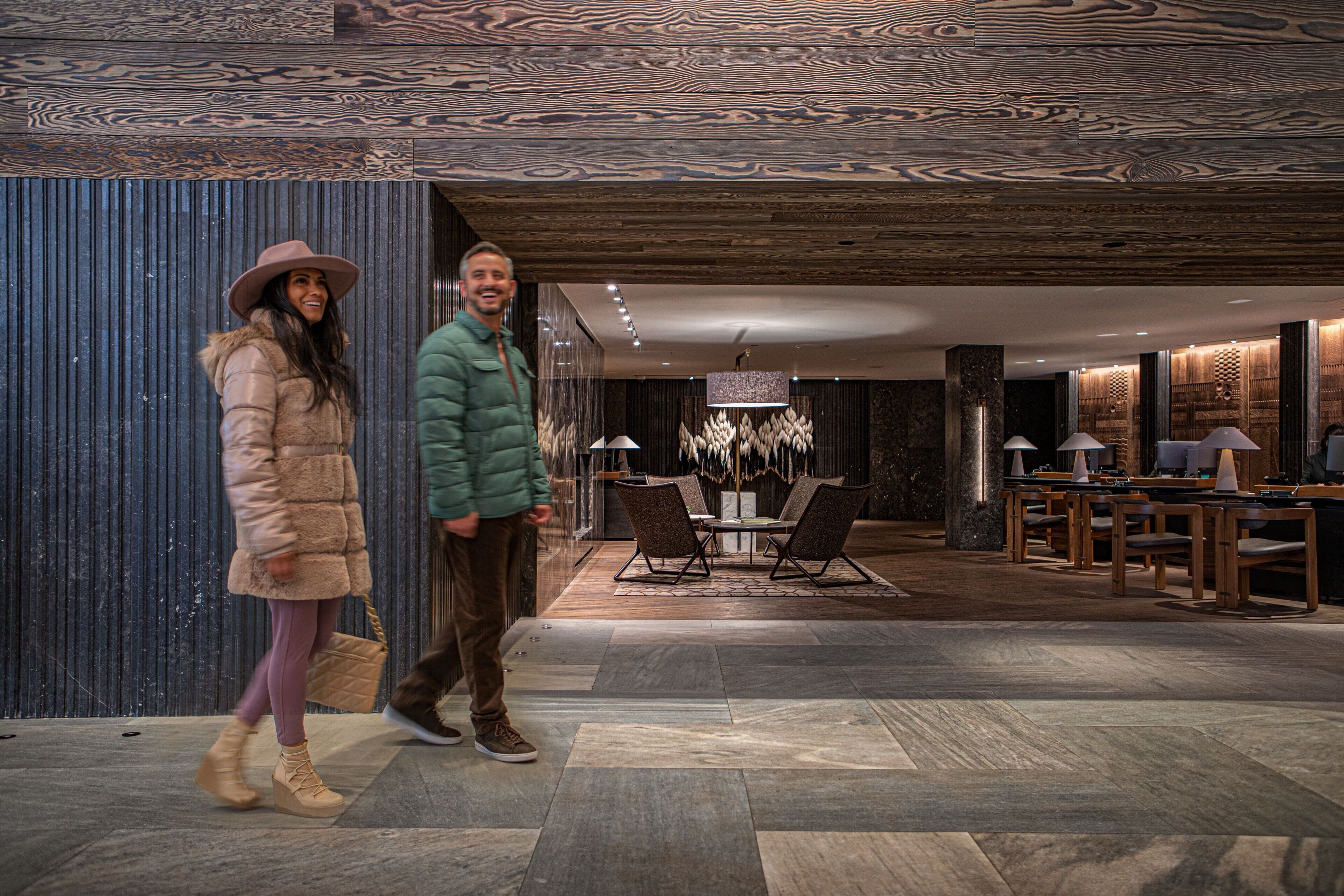Een modern interieur met een eetgedeelte, inclusief een kroonluchter, houten tafels en stoelen.