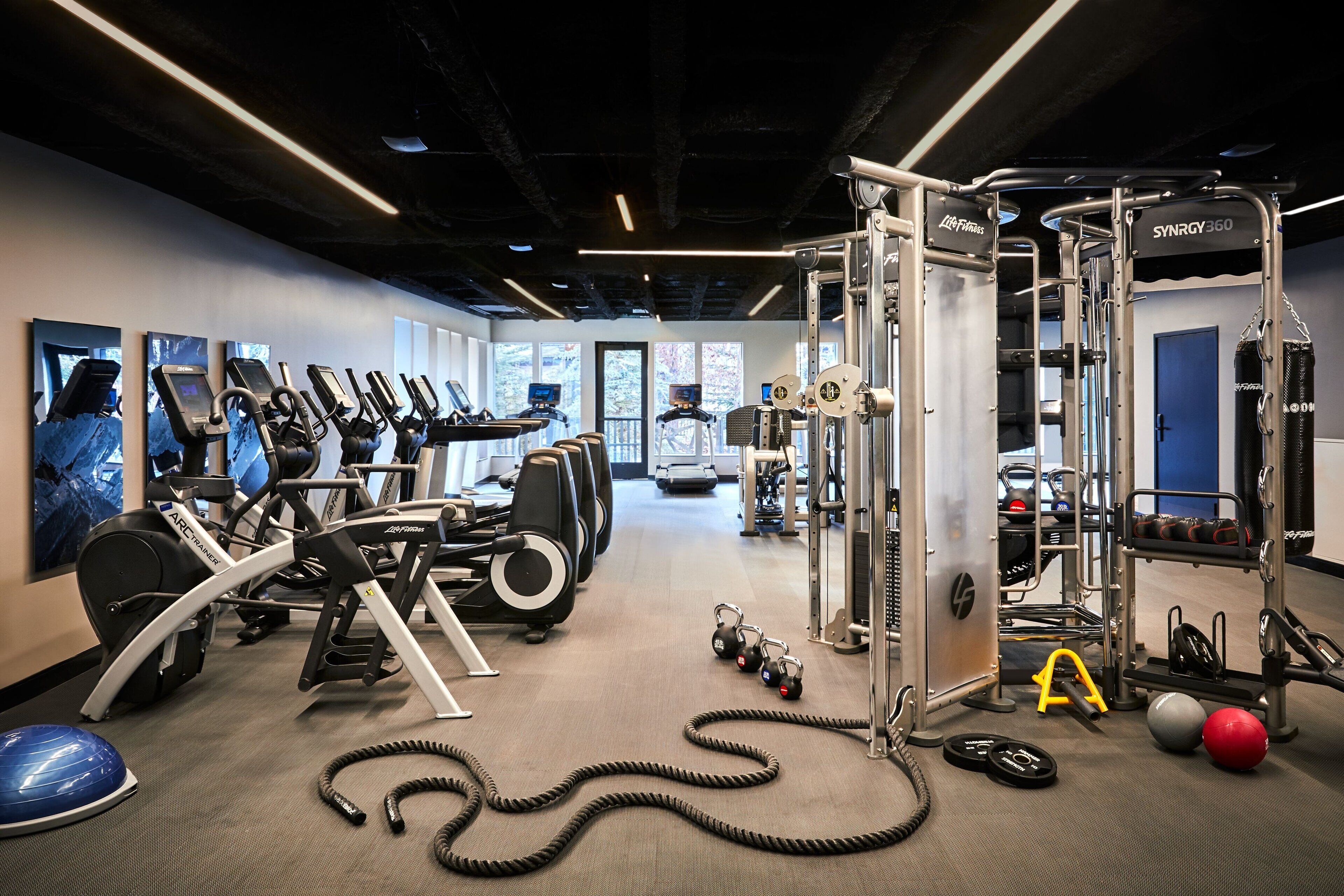A gym with cardio machines, weightlifting equipment, and exercise balls.