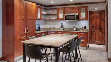 A modern kitchen with wooden cabinets, a stainless steel microwave, and a granite countertop.