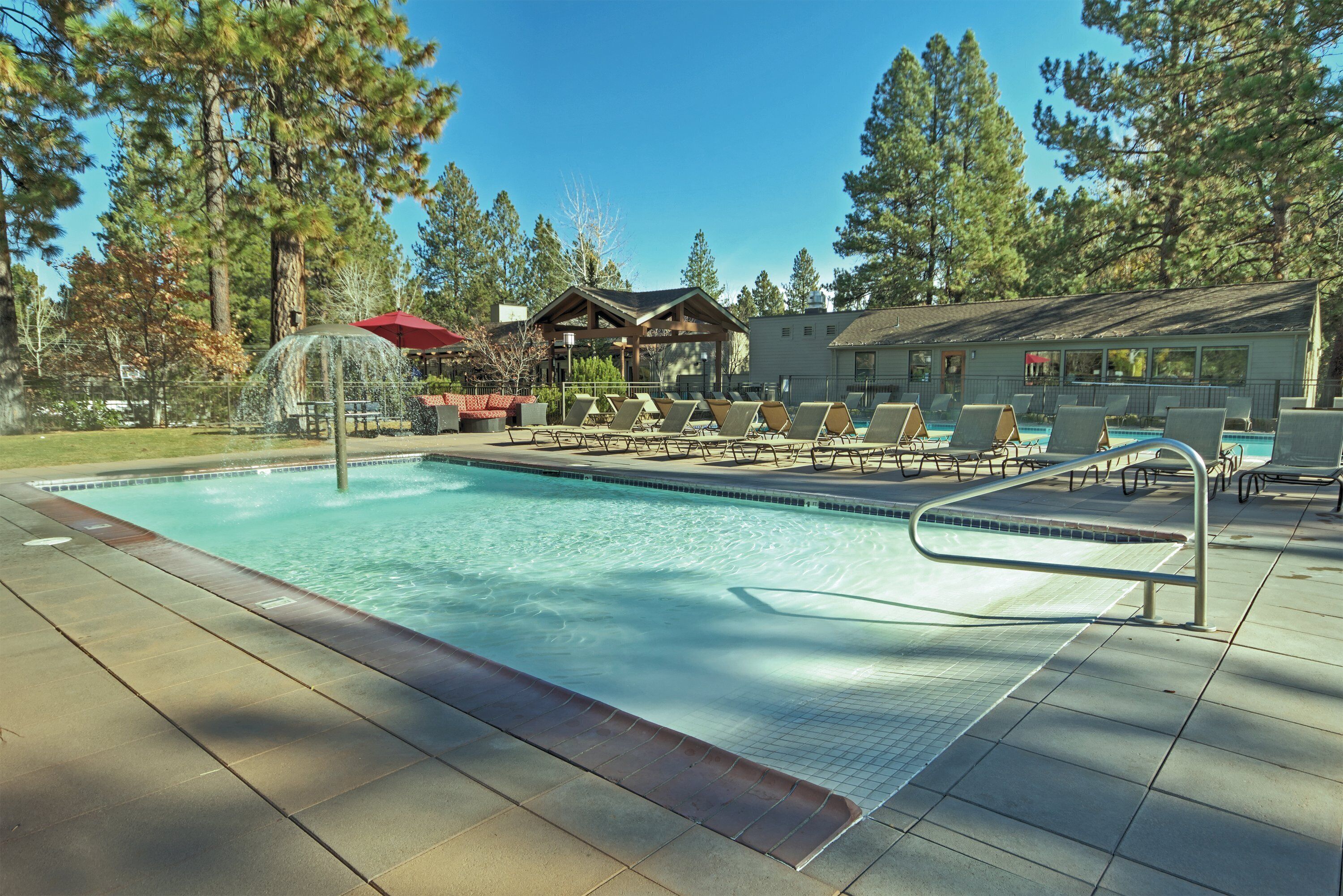 A swimming pool with lounge chairs and a gazebo.