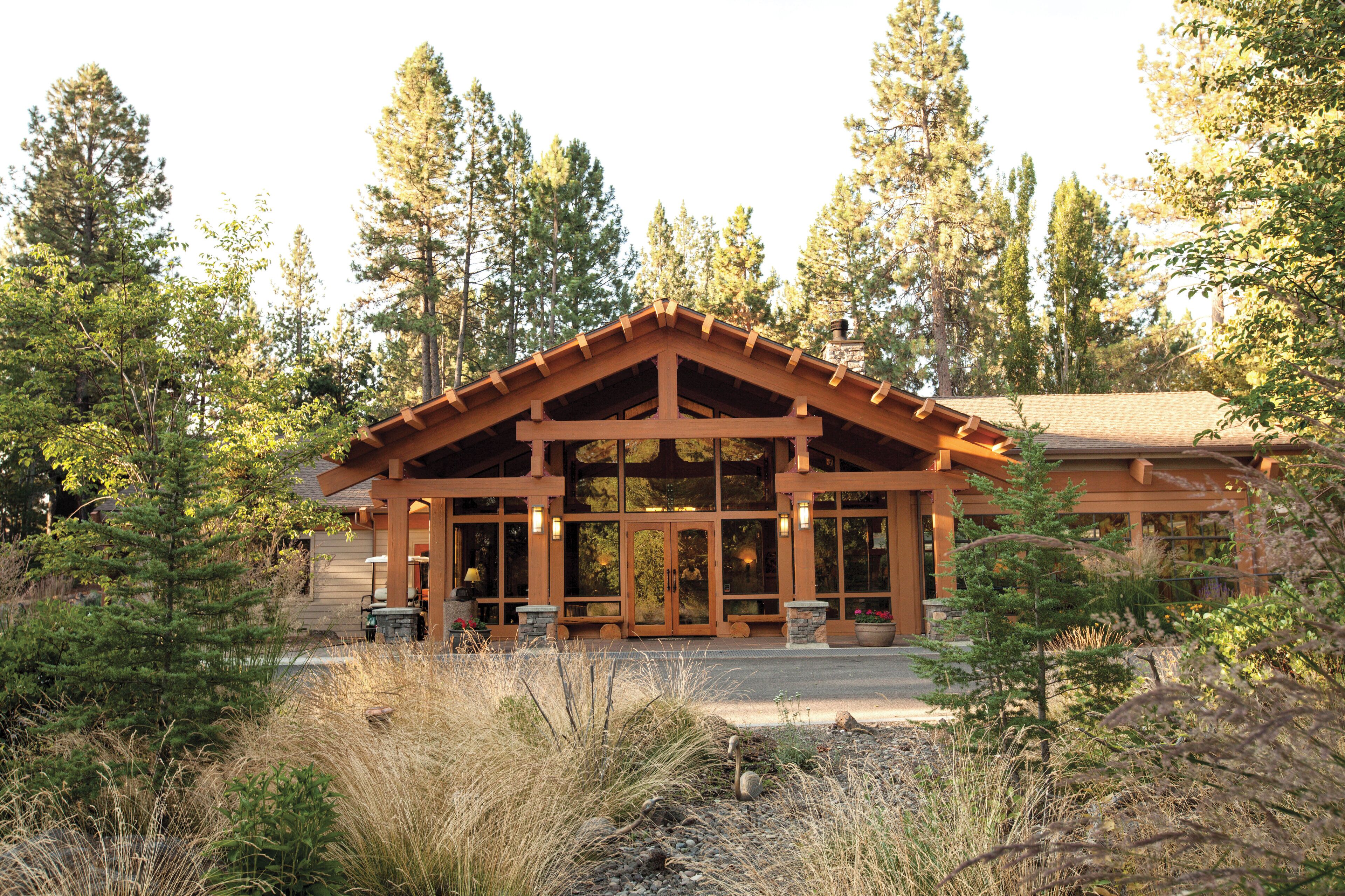 A lodge with a wooden facade, large windows, and a stone entrance.