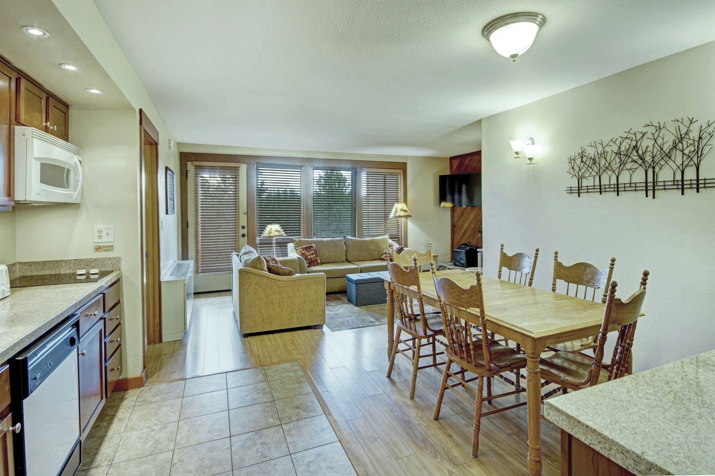 A compact kitchen with a dining area, a microwave, and a dining table with chairs.