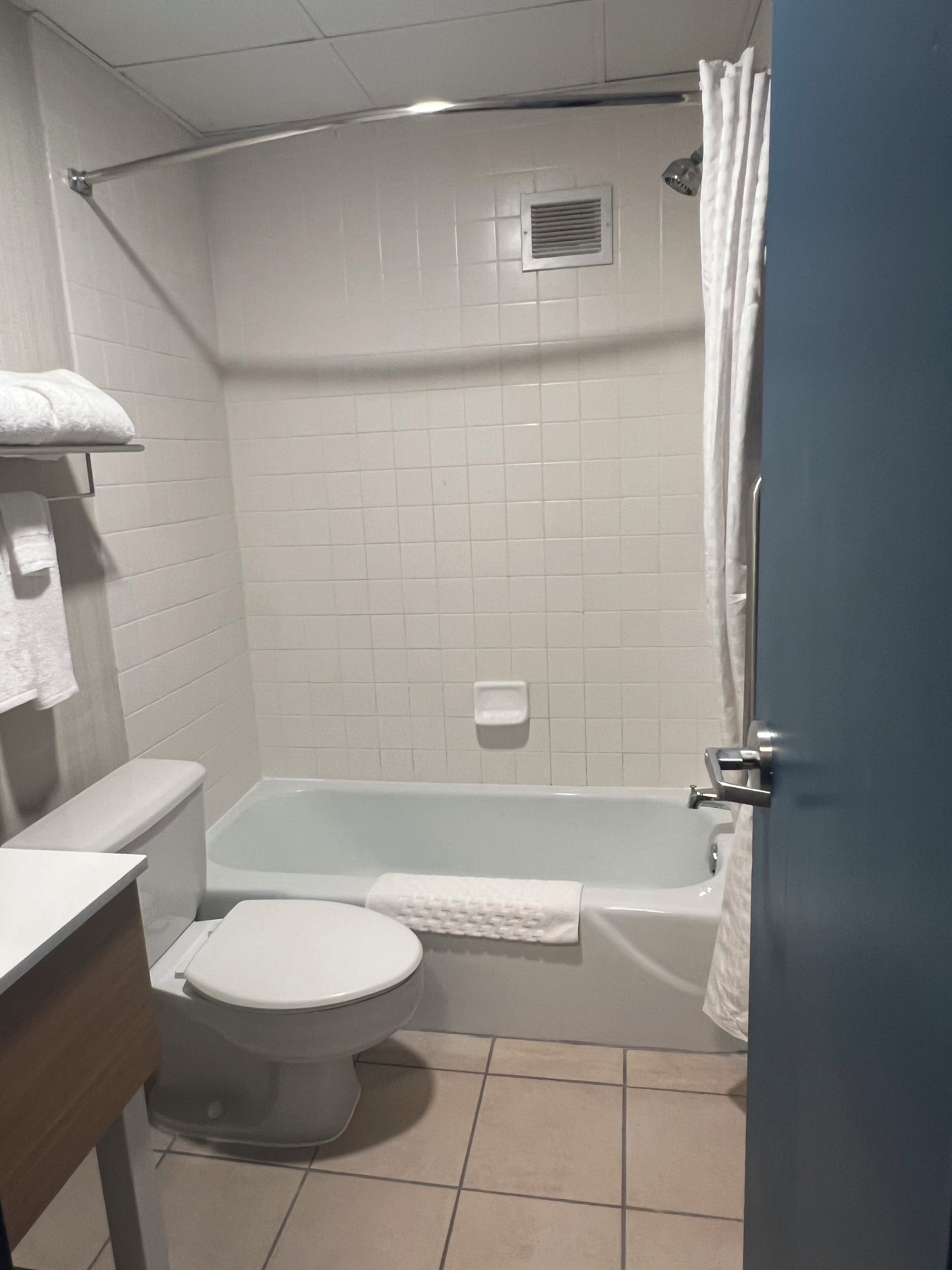 Une salle de bain équipée de toilettes, d’une baignoire et d’un rideau de douche.