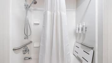 Un bagno moderno con doccia, maniglie di sostegno, asciugamani ad aria e articoli da toilette.