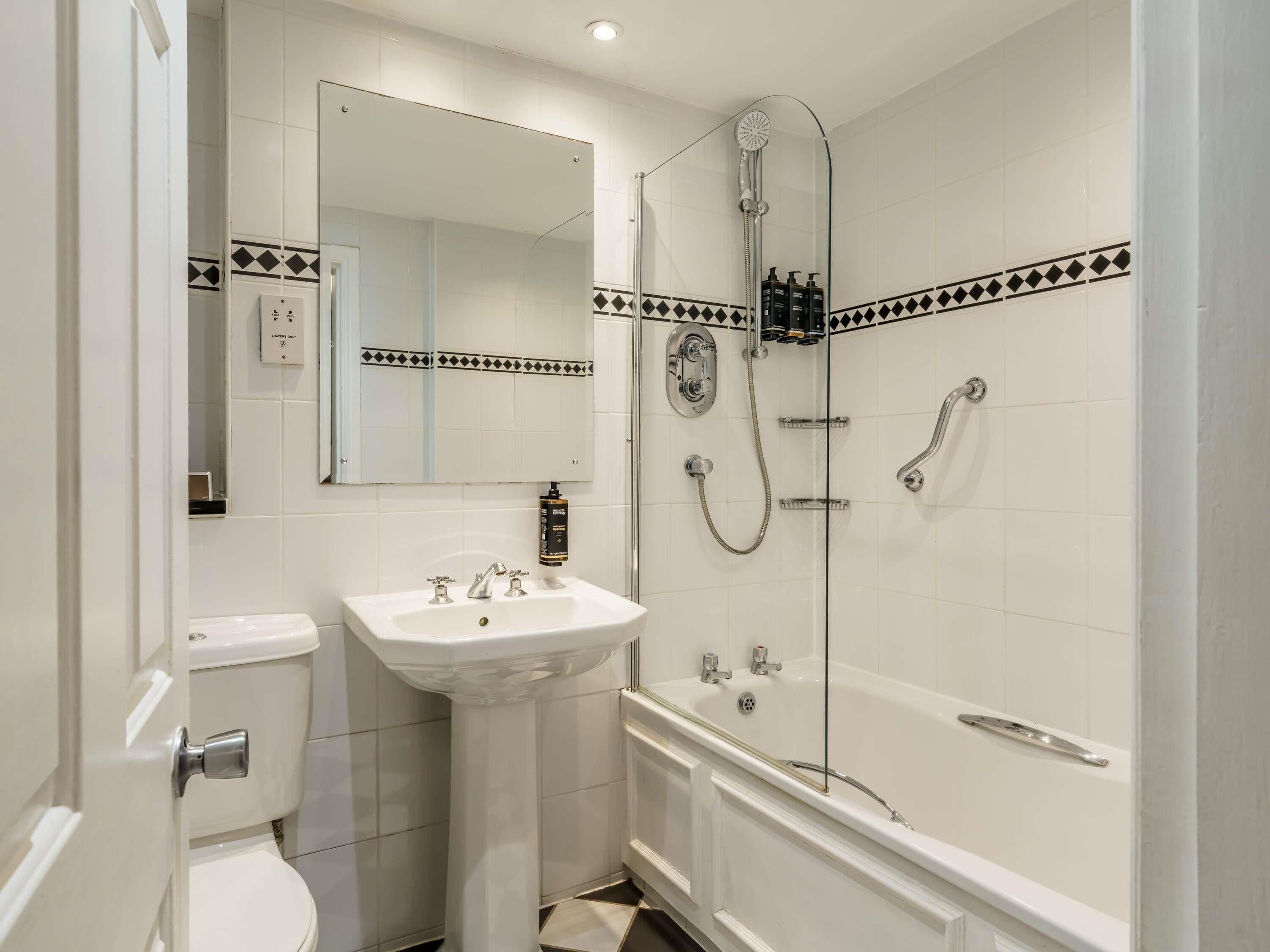 A bathroom with a toilet, sink, and bathtub.