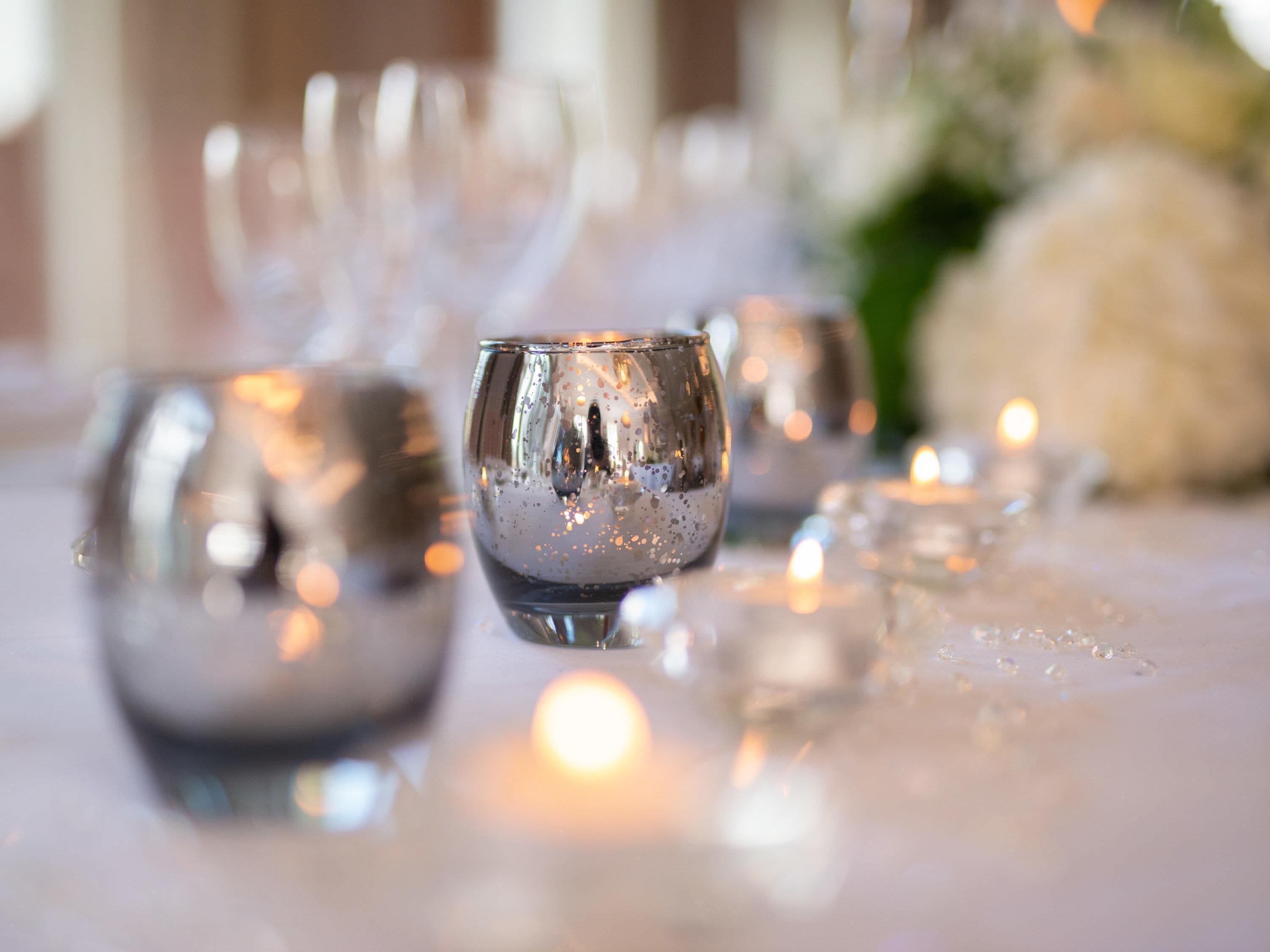 A table setting with multiple glasses and candles.