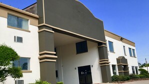 Un edificio moderno con techo plano, ventanas amplias y una entrada central.