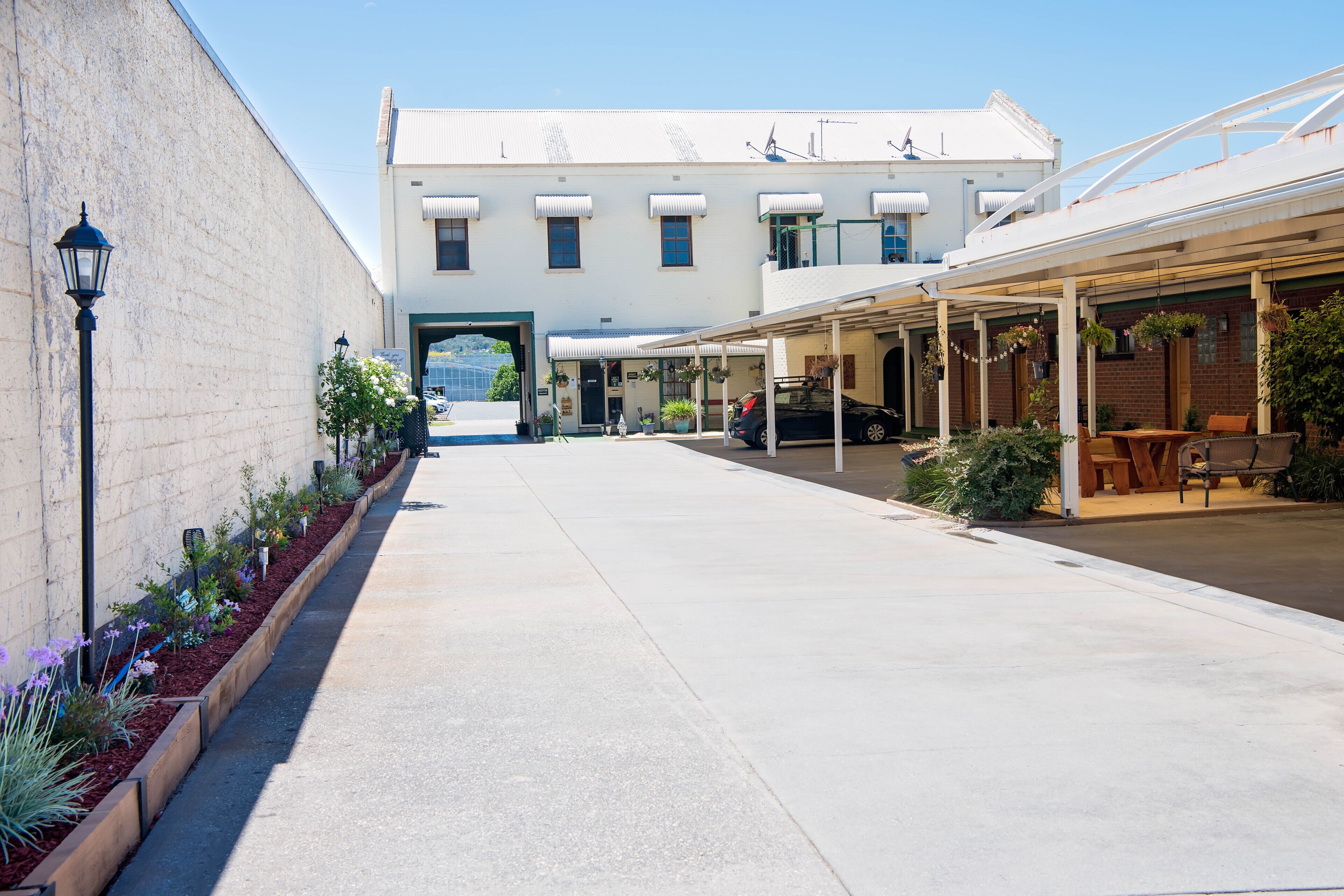 A building with a covered outdoor seating area and a garage entrance.