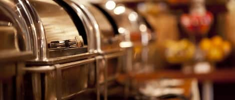 A buffet setup with stainless steel appliances and a glassware holder.